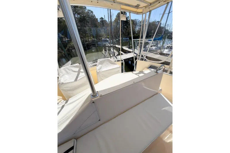 Slide: The Image of 1988 Pacemaker 36 Convertible boat interior with white seating and marina view. - 24