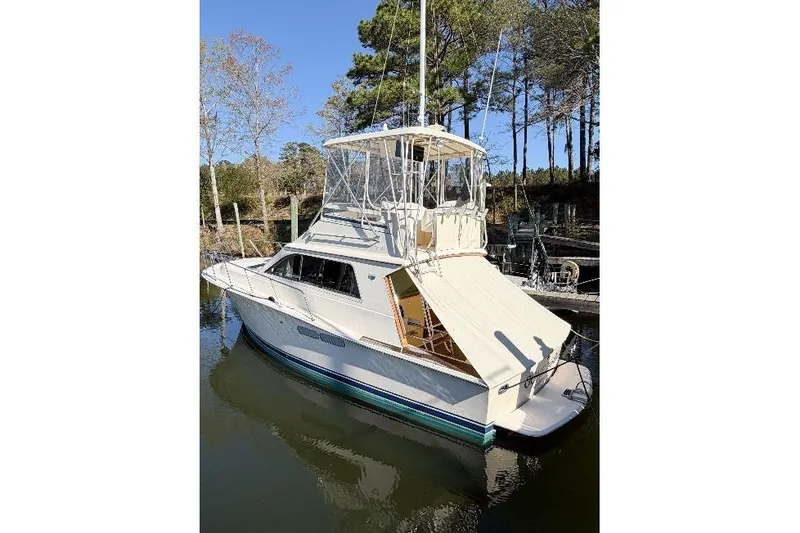 Slide: The Image of 1988 Pacemaker 36 Convertible boat docked in a serene marina setting. - 3