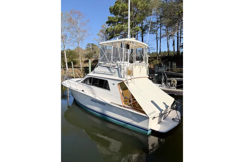Slide: The Image of 1988 Pacemaker 36 Convertible boat docked in a serene wooded area. - 4