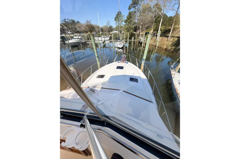 Slide: The Image of 1988 Pacemaker 36 Convertible yacht docked in a serene marina setting. - 42