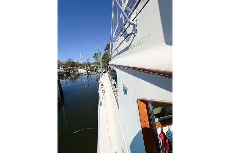Slide: The Image of 1988 Pacemaker 36 Convertible yacht docked by calm waters under clear blue sky. - 44