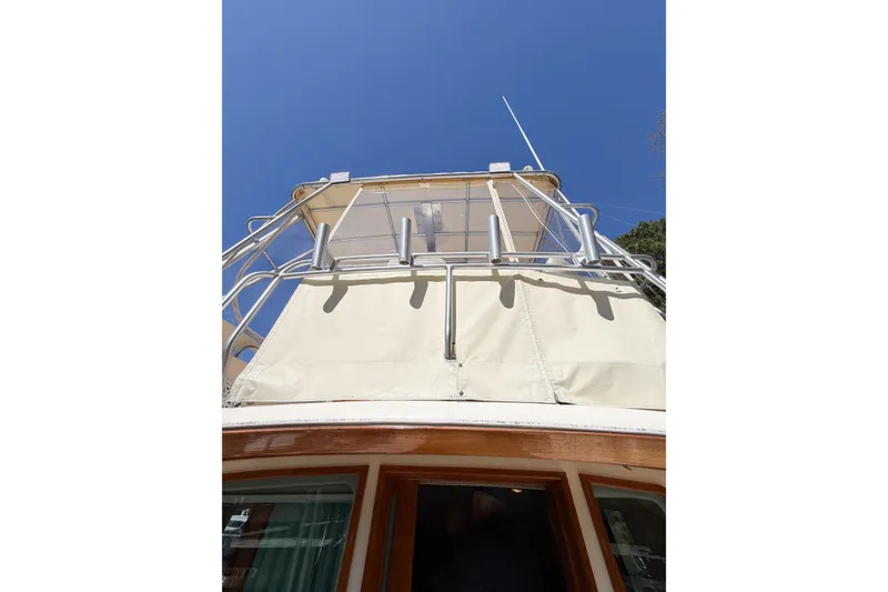 Slide: The Image of 1988 Pacemaker 36 Convertible yacht with upper deck and railing against clear blue sky. - 48