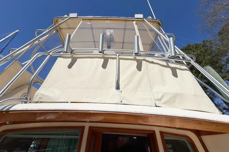 Slide: The Image of 1988 Pacemaker 36 Convertible boat with upper deck and railing under clear blue sky. - 49