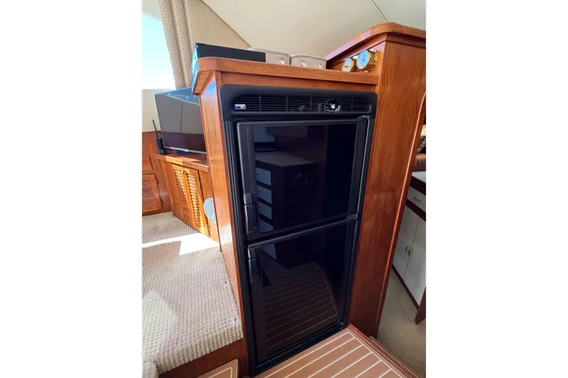Slide: The Image of 1988 Pacemaker 36 Convertible interior with black fridge and wooden cabinetry. - 78