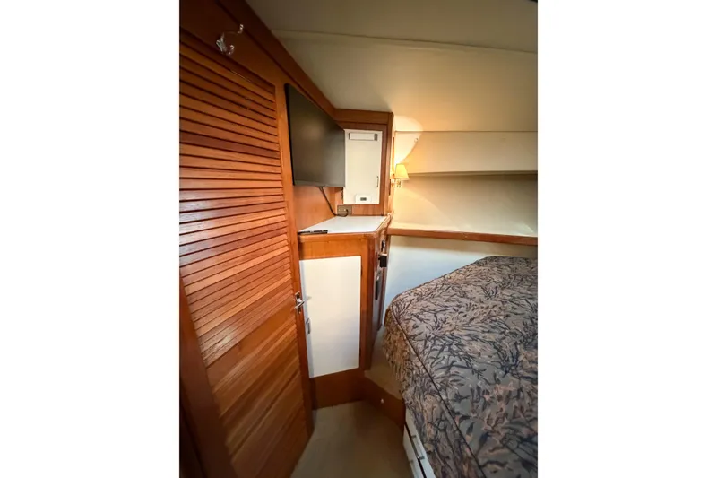 Slide: The Image of Interior of 1988 Pacemaker 36 Convertible yacht with wooden cabinetry and cozy bedding. - 93