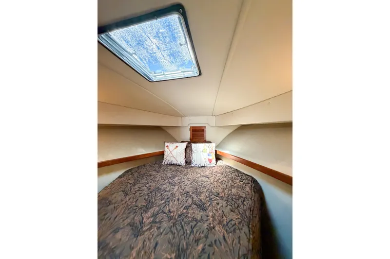 Slide: The Image of Cozy cabin interior of 1988 Pacemaker 36 Convertible yacht with skylight and bedding. - 95