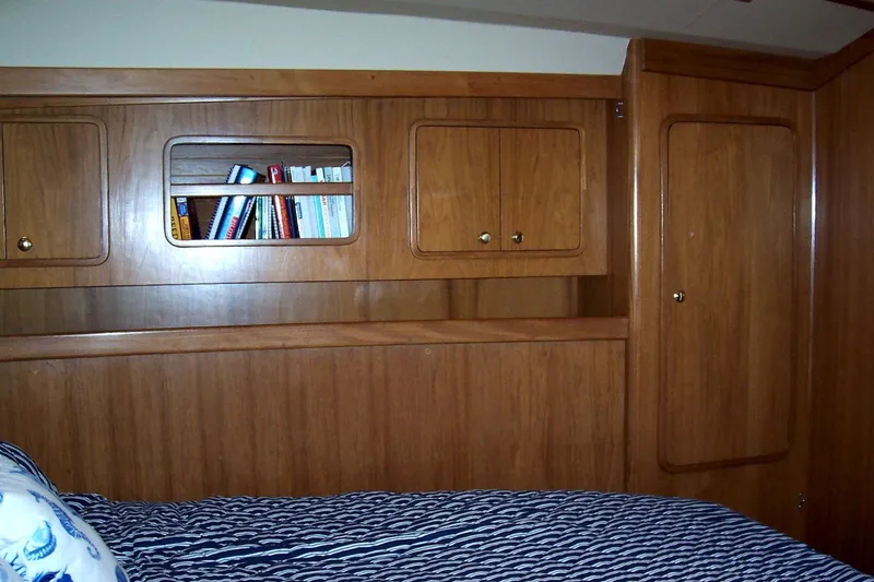 Slide: The Image of Wood-paneled cabin interior of 1994 C&C 51' XL / CB yacht with bookshelf and bed. - 27