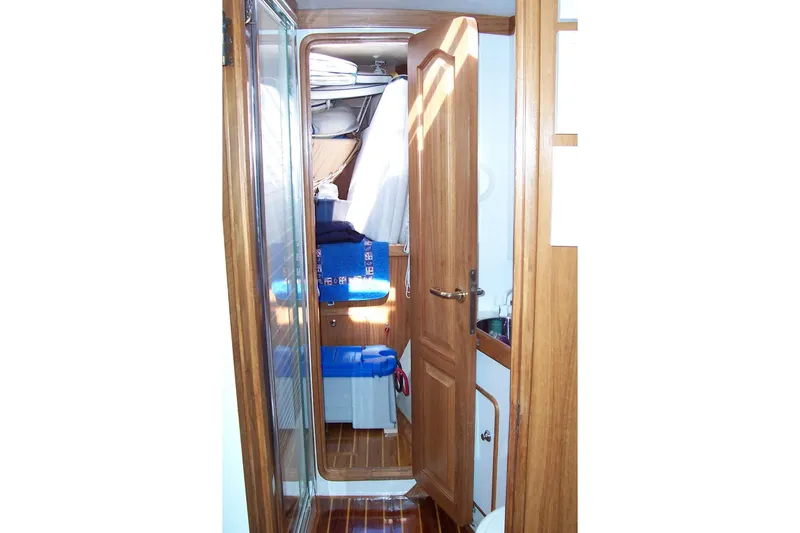 Slide: The Image of Interior of 1994 C&C 51' XL / CB yacht, featuring wooden cabinetry and cozy sleeping area. - 28