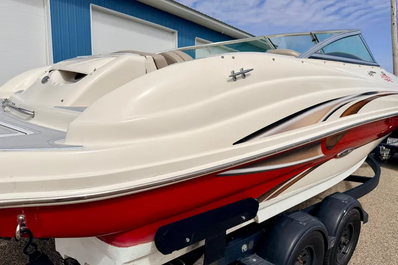 Slide: The Image of 2003 Sea Ray 200 Sundeck boat with red and white design on a trailer. - 11