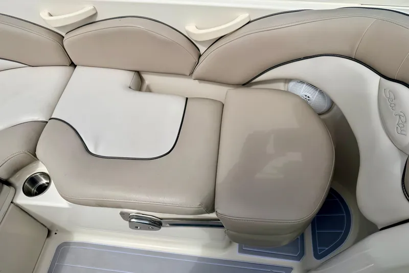 Slide: The Image of 2003 Sea Ray 200 Sundeck interior seating with beige upholstery and cup holder. - 24