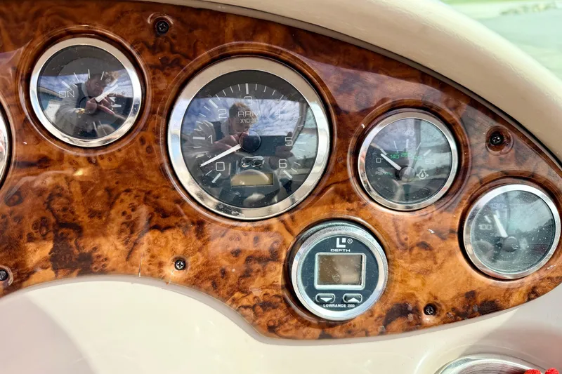 Slide: The Image of Dashboard of a 2003 Sea Ray 200 Sundeck boat with wood grain finish and gauges. - 30