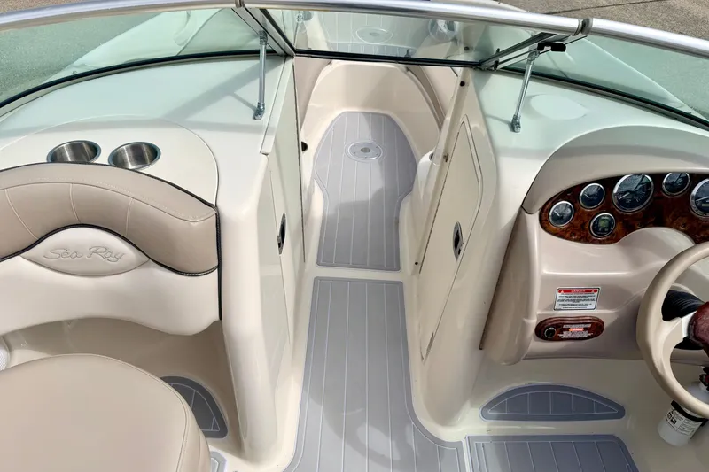 Slide: The Image of 2003 Sea Ray 200 Sundeck interior with beige seating and dashboard controls. - 35