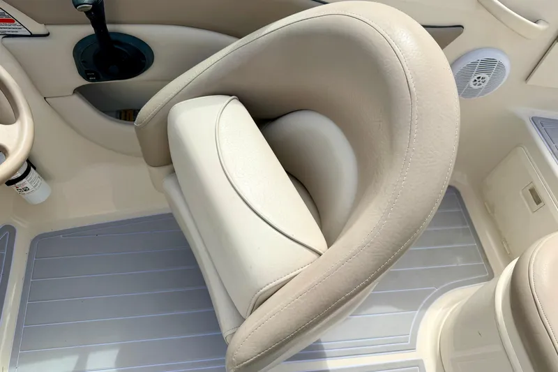 Slide: The Image of 2003 Sea Ray 200 Sundeck boat interior with beige seating and steering wheel. - 56