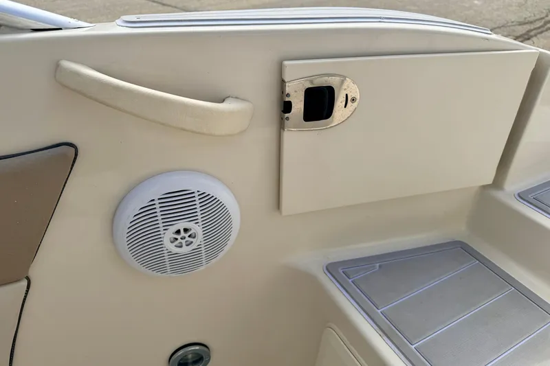 Slide: The Image of Interior of 2003 Sea Ray 200 Sundeck showing speaker, handle, and storage compartment. - 58