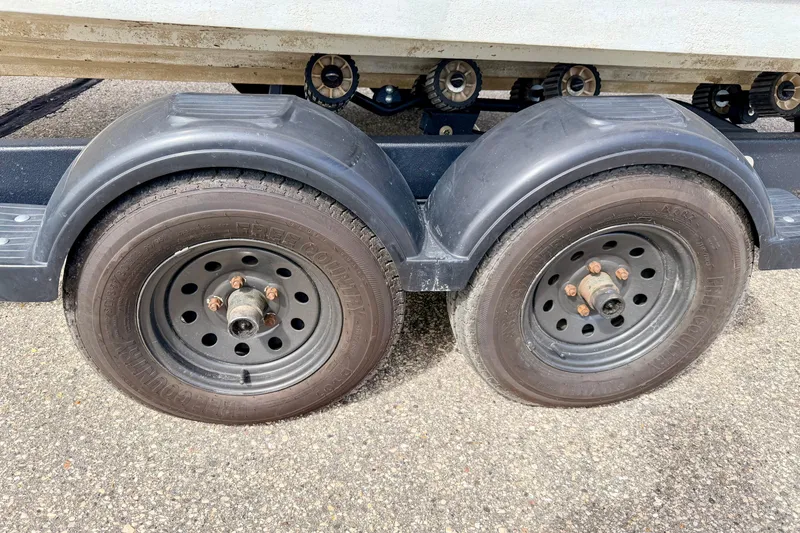 Slide: The Image of Trailer wheels for 2003 Sea Ray 200 Sundeck boat on pavement. - 66