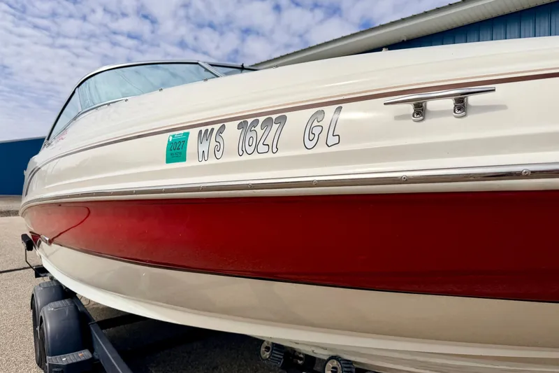 Slide: The Image of 2003 Sea Ray 200 Sundeck boat with red and white hull on trailer. - 7