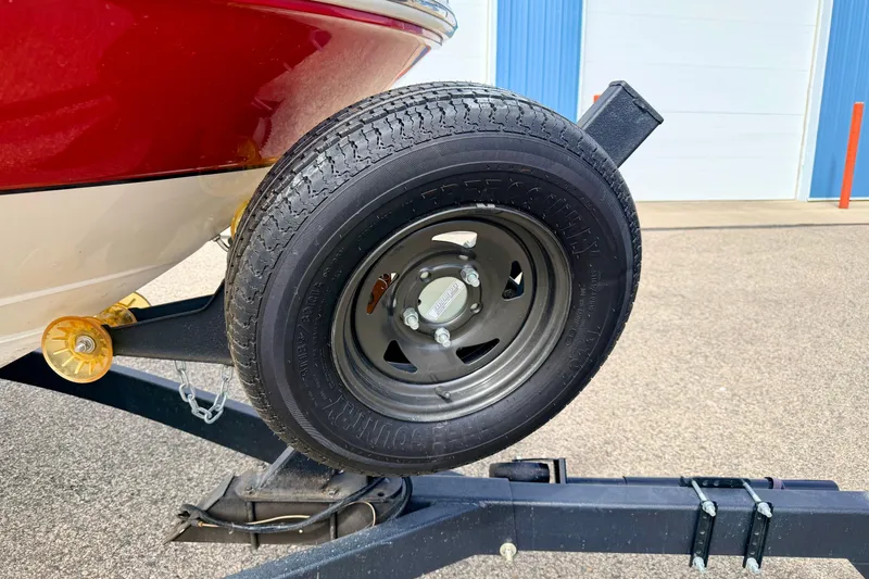 Slide: The Image of Trailer wheel of a 2003 Sea Ray 200 Sundeck boat, parked on pavement. - 8