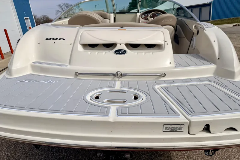 Slide: The Image of 2003 Sea Ray 200 Sundeck boat, rear view, showcasing spacious deck and seating area. - 9