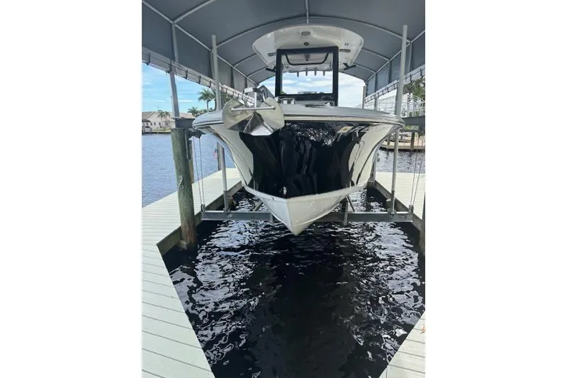 The Image of 2017 Sea Hunt Gamefish 25 boat on lift at dockside, under canopy. - 0