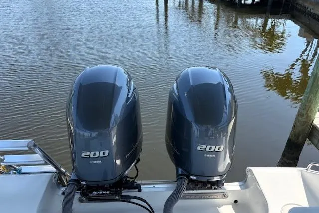 Slide: The Image of Twin Yamaha 200 engines on a 2017 Sea Hunt Gamefish 25 boat by the water. - 10