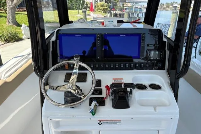 Slide: The Image of 2017 Sea Hunt Gamefish 25 helm with dual screens and steering wheel. - 11