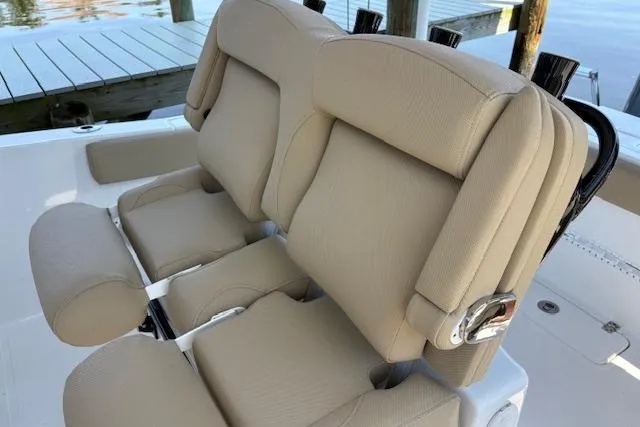 Slide: The Image of 2017 Sea Hunt Gamefish 25 boat with beige cushioned seats and rod holders. - 13