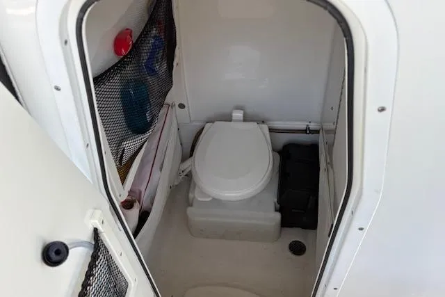 Slide: The Image of 2017 Sea Hunt Gamefish 25 boat interior with compact marine toilet. - 15