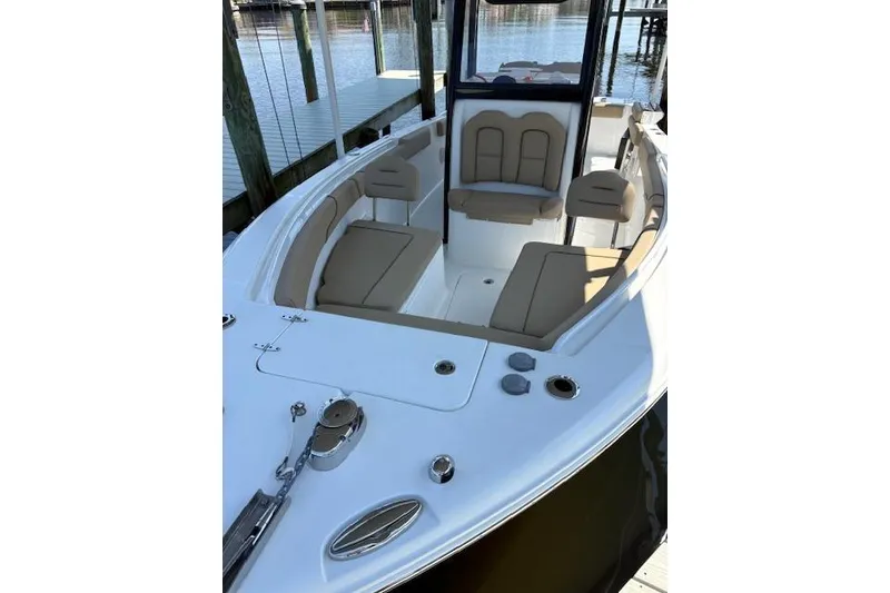 Slide: The Image of 2017 Sea Hunt Gamefish 25 boat with spacious seating and sleek design at a dock. - 17