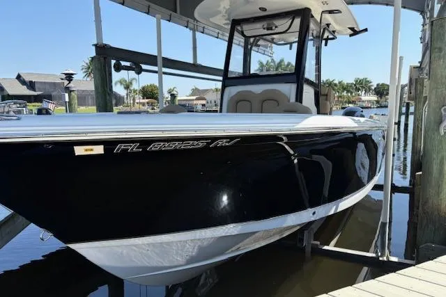 Slide: The Image of 2017 Sea Hunt Gamefish 25 boat docked, black hull, sunny marina setting. - 2