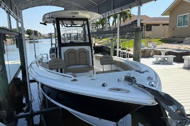 Slide: The Image of 2017 Sea Hunt Gamefish 25 boat docked under canopy in sunny waterfront setting. - 3