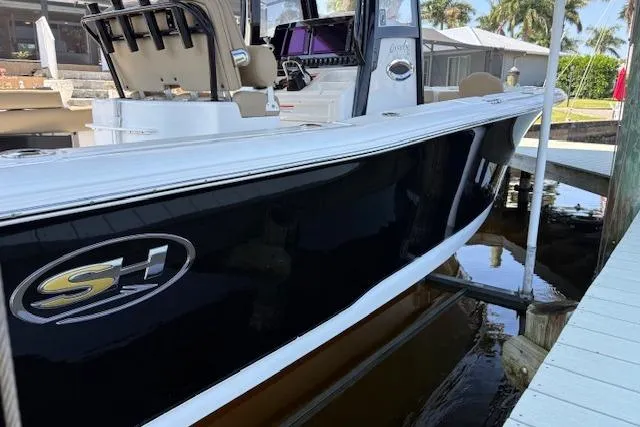 Slide: The Image of 2017 Sea Hunt Gamefish 25 boat docked, featuring sleek black hull and modern design. - 4