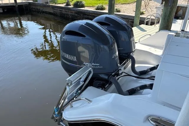 Slide: The Image of 2017 Sea Hunt Gamefish 25 with twin Yamaha outboard motors docked by water. - 9