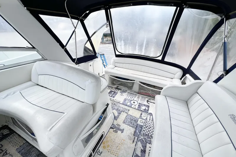 Slide: The Image of Interior of a 2000 Rinker Fiesta Vee 330 boat with white seating and nautical decor. - 11