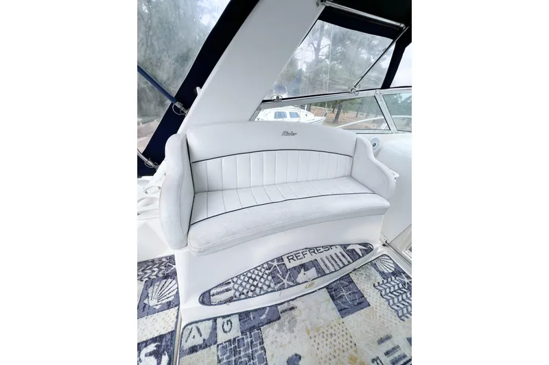 Slide: The Image of White seating area on a 2000 Rinker Fiesta Vee 330 boat, featuring a patterned carpet. - 17