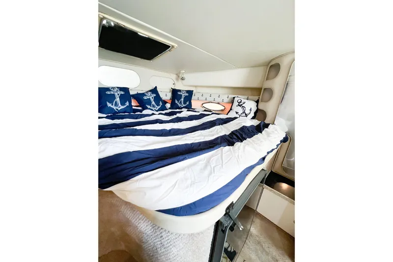 Slide: The Image of Cozy cabin interior of 2000 Rinker Fiesta Vee 330 with nautical-themed bedding. - 21