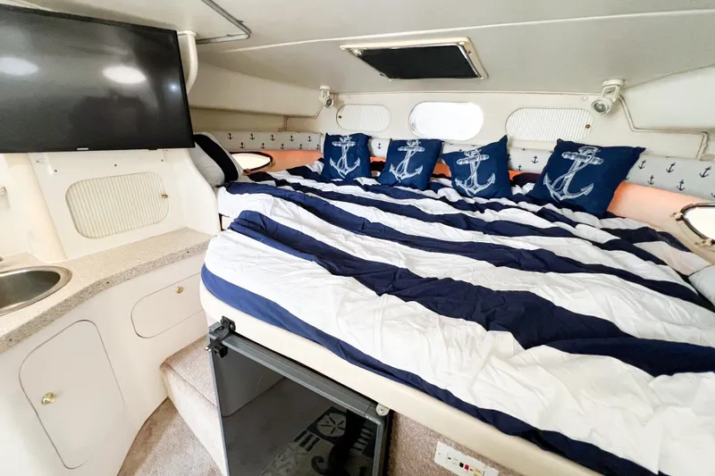 Slide: The Image of Interior of 2000 Rinker Fiesta Vee 330 with nautical-themed bedding and modern amenities. - 22
