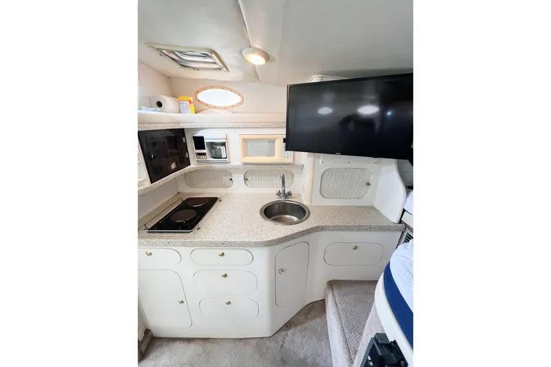 Slide: The Image of 2000 Rinker Fiesta Vee 330 interior kitchen with sink, stove, and TV. - 23