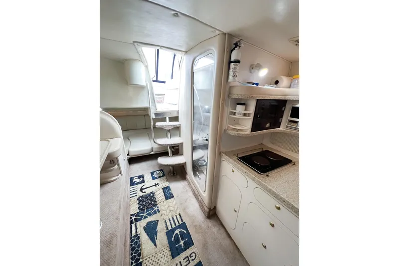 Slide: The Image of Interior of 2000 Rinker Fiesta Vee 330 boat with kitchenette and seating area. - 25