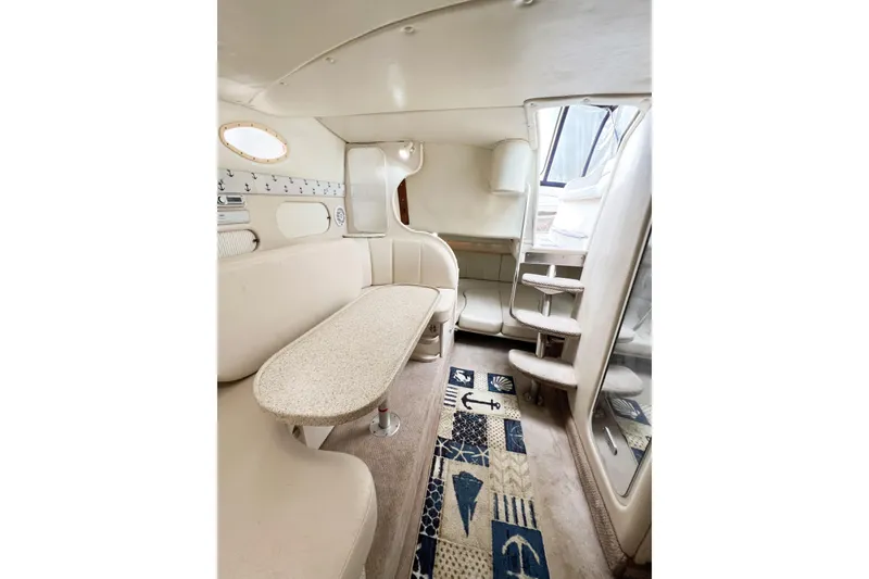 Slide: The Image of Interior of 2000 Rinker Fiesta Vee 330 boat with beige seating and nautical-themed decor. - 26