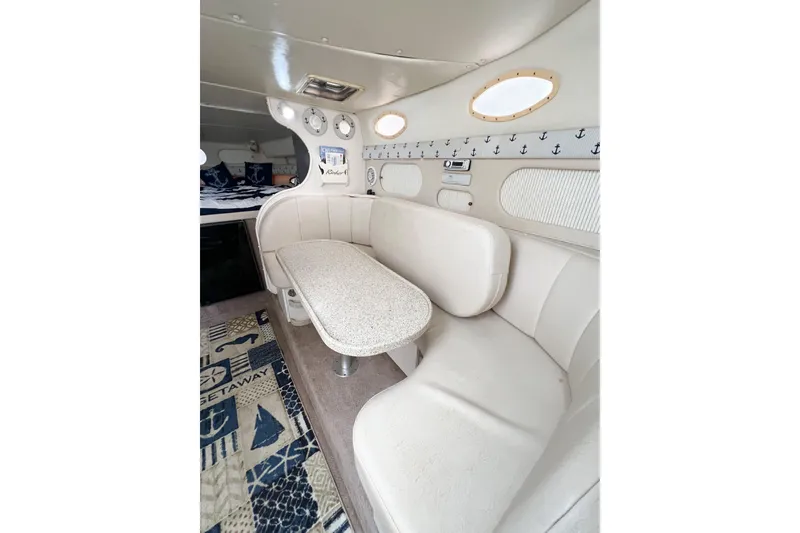 Slide: The Image of Interior of 2000 Rinker Fiesta Vee 330 boat with beige seating and nautical decor. - 28