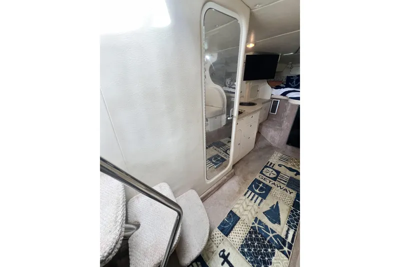 Slide: The Image of Interior of 2000 Rinker Fiesta Vee 330 boat with mirror, TV, and nautical decor. - 30