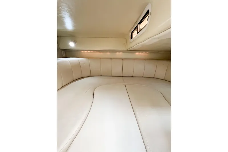 Slide: The Image of Interior cabin of 2000 Rinker Fiesta Vee 330 boat, featuring plush seating and ambient lighting. - 34