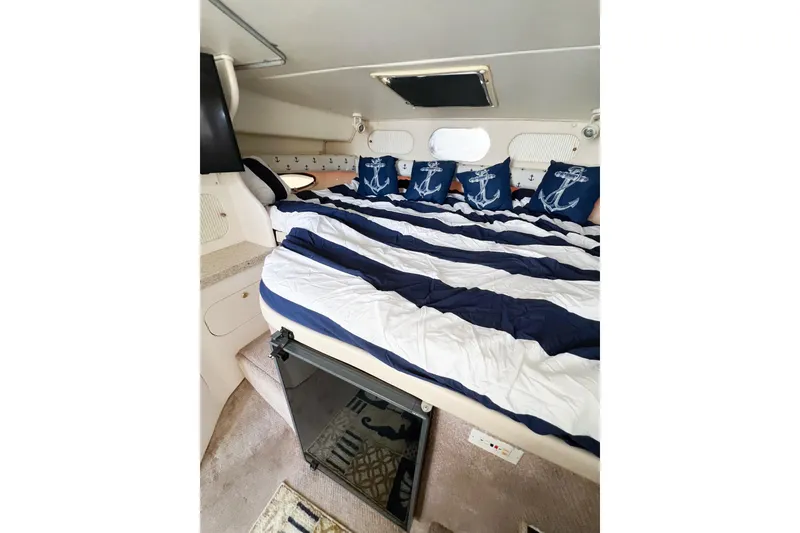 Slide: The Image of Interior of 2000 Rinker Fiesta Vee 330 with nautical-themed bedding and cozy cabin space. - 39