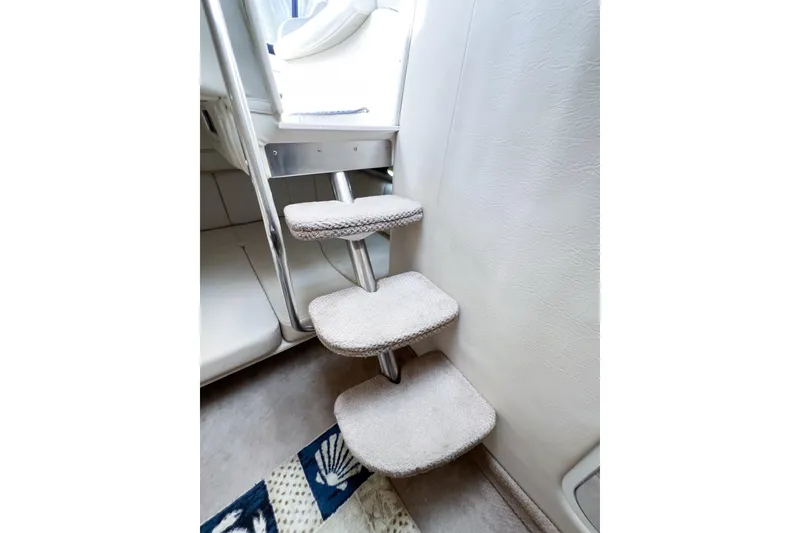 Slide: The Image of Interior stairs of a 2000 Rinker Fiesta Vee 330 boat, featuring carpeted steps. - 40
