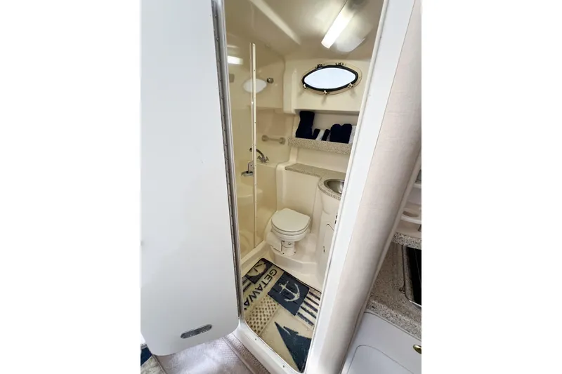 Slide: The Image of 2000 Rinker Fiesta Vee 330 bathroom interior with toilet, sink, and nautical decor. - 42
