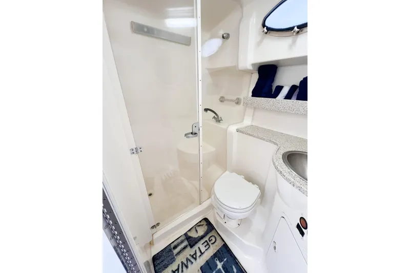 Slide: The Image of Bathroom interior of 2000 Rinker Fiesta Vee 330 boat, featuring shower, toilet, and sink. - 44