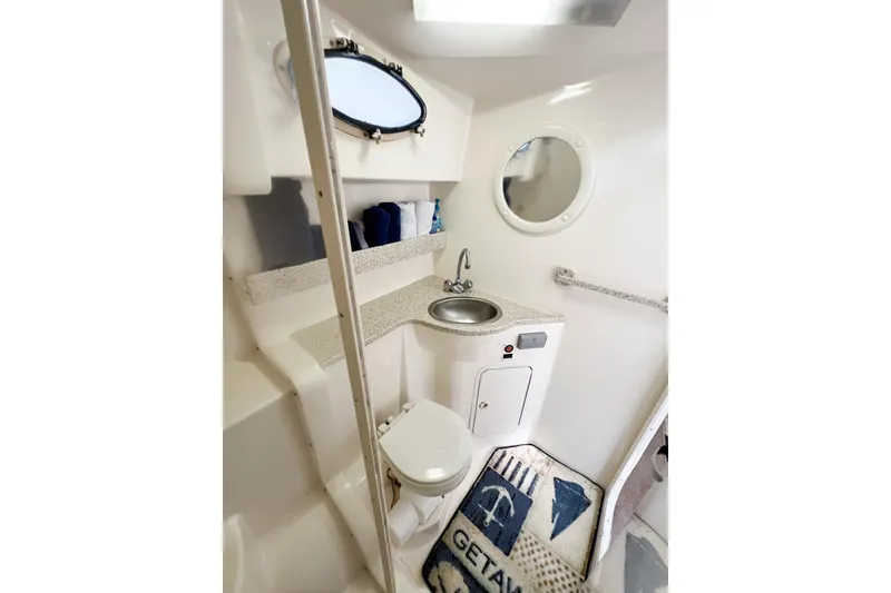 Slide: The Image of 2000 Rinker Fiesta Vee 330 boat bathroom with sink, toilet, and nautical decor. - 45