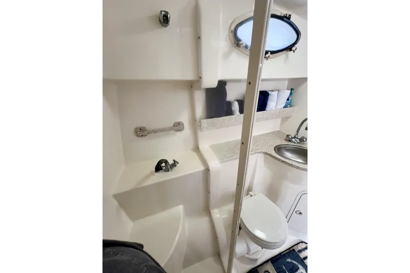 Slide: The Image of Bathroom interior of 2000 Rinker Fiesta Vee 330 boat with sink, toilet, and porthole. - 46