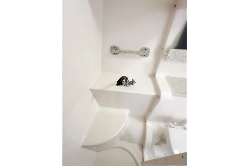 Slide: The Image of Interior of 2000 Rinker Fiesta Vee 330 boat, featuring a compact bathroom area. - 47