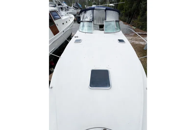 Slide: The Image of 2000 Rinker Fiesta Vee 330 boat deck view, featuring white surface and cabin windows. - 63